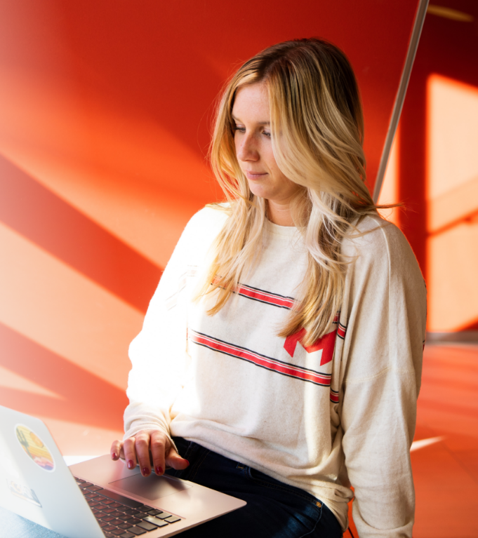 Student working on their laptop in a Maryville sweater